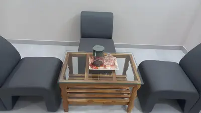 two chairs and a table with a bottle on it at Maruthamalai Andavar Residency in Coimbatore