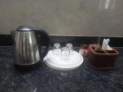 a coffee pot and glasses sitting on a counter at Maruthamalai Andavar Residency in Coimbatore