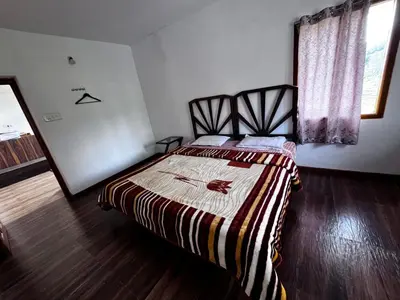 a bedroom with a bed with a striped blanket at Ken valley homes & villa in Lovedale