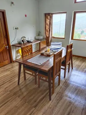 a dining room with a wooden table and chairs at Ken valley homes & villa in Lovedale