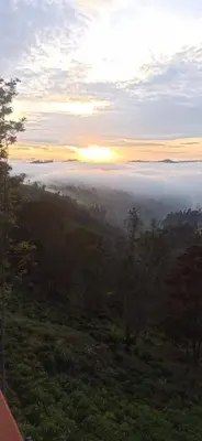 a view of a foggy valley with the sun rising over the ocean at Ken valley homes & villa in Lovedale