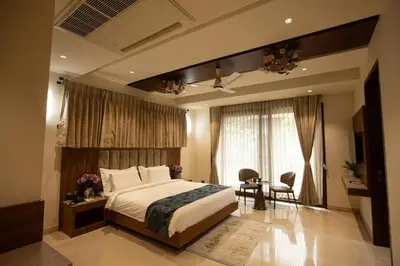 a bedroom with a bed and a table and chairs at Rosse Dale Suites and Hotel Coimbatore in Coimbatore