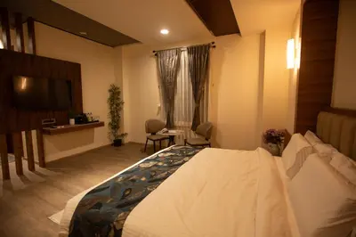 a hotel room with a bed and a television at Rosse Dale Suites and Hotel Coimbatore in Coimbatore