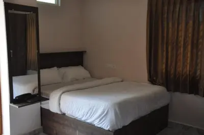 a bedroom with two beds and a mirror on the wall at Parvathi comforts inn in Mysore
