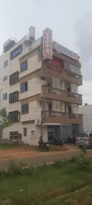 a building with a motorcycle parked in front of it at Parvathi comforts inn in Mysore