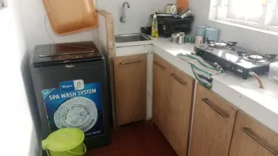 a small kitchen with a stove and a sink at Suraj Stays Glowing Meadows in Chewarra