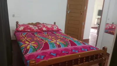 a bed with a colorful comforter and pillows at Suraj Stays Glowing Meadows in Chewarra