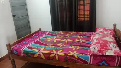 a bed with a colorful blanket on top of it at Suraj Stays Glowing Meadows in Chewarra