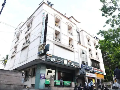 a large white building on a city street at Hotel Grand Palace in Coimbatore