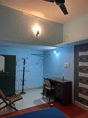 a room with a table and a cross on the wall at Fog view cottage - Homestay with food and internet in Vythiri
