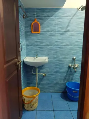 a bathroom with a sink and a bucket at love moon home stay in Mysore
