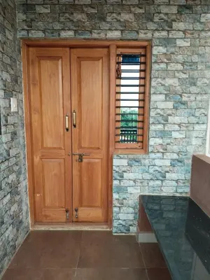 a wooden door in a stone wall with a window at love moon home stay in Mysore