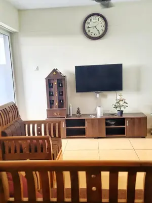 a living room with a television and a clock on the wall at City Nature-view apartment in Kozhikode