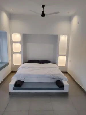 a bedroom with a bed with lights on the wall at 3BHK - Villa - a greece style - Kayal vizha - near isha yoga - coimbatore in Coimbatore