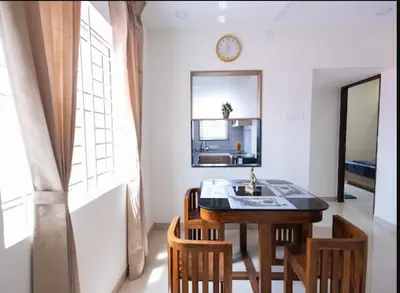 a kitchen with a table and chairs and a sink at Sree Home Stay and Service Apartment Coimbatore in Irugūr