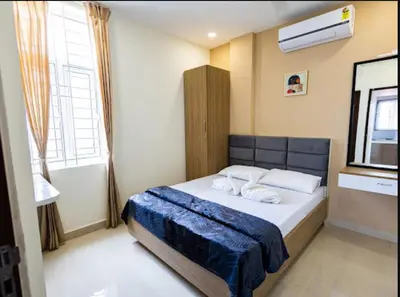 a bedroom with a bed with a blue blanket on it at Sree Home Stay and Service Apartment Coimbatore in Irugūr