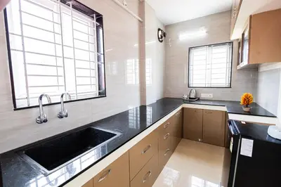 a kitchen with a sink and two windows at Sree Home Stay and Service Apartment Coimbatore in Irugūr