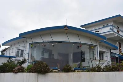 a house with a large window in front of it at diamond hill view cottage in Ooty