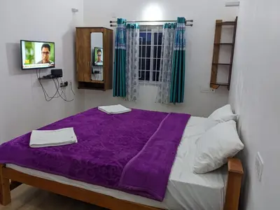 a bedroom with a purple blanket on a bed at diamond hill view cottage in Ooty
