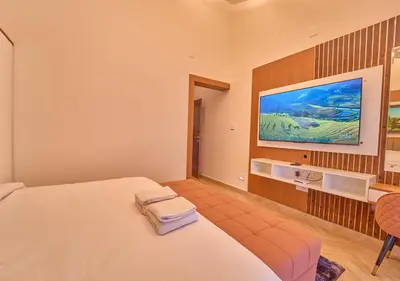 a hotel room with a bed and a tv at Villa Terra Verde Ooty by VOYE HOMES in Ooty
