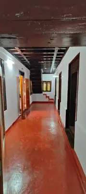 an empty room with a red floor in a building at Traditional Kerala house, Kannur-Thalassery in Tellicherry