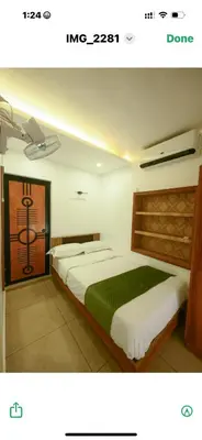 a bedroom with two beds in a room with a door at Paradise-Vadanappally Beach Villa for 4-5 adults in Irimbranallūr