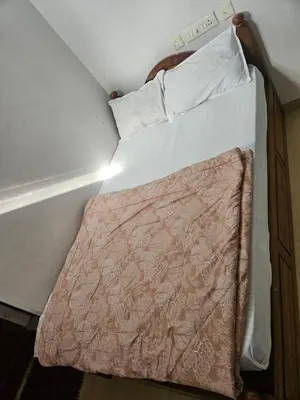 two beds in a small room with avertisement for at grandresidency in Kāladi
