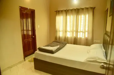 a bedroom with a large bed with a window at Mysuru Family Home Stay in Mysore