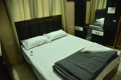 a bedroom with a bed with a black headboard and a mirror at Mysuru Family Home Stay in Mysore