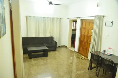 a living room with a couch and a table at Mysuru Family Home Stay in Mysore