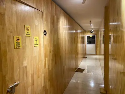 a hallway with wooden walls with signs on it at The Marina Kozhikode AC Rooms and Dorms Opposite to Beach in Kozhikode
