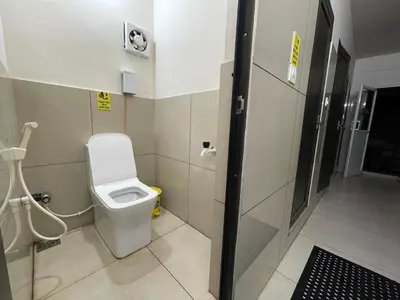 a bathroom with a toilet in a stall at The Marina Kozhikode AC Rooms and Dorms Opposite to Beach in Kozhikode