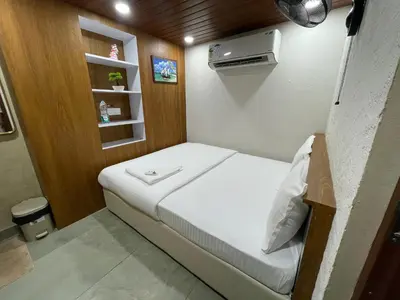 a small bedroom with a bed in a room at The Marina Kozhikode AC Rooms and Dorms Opposite to Beach in Kozhikode