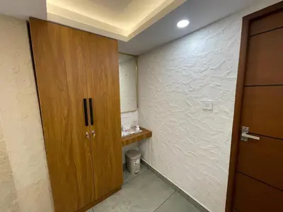a bathroom with a wooden cabinet and a toilet at The Marina Kozhikode AC Rooms and Dorms Opposite to Beach in Kozhikode