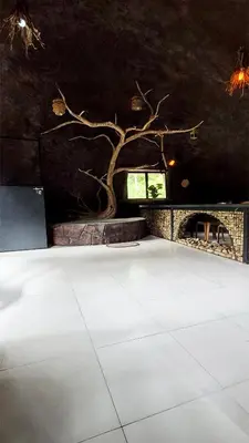 a room with a tree and a fireplace at Mamalakandam Rock Cave at Diya Homestay in Mamalakandam