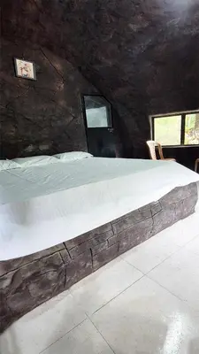 a large bed in a room with two windows at Mamalakandam Rock Cave at Diya Homestay in Mamalakandam