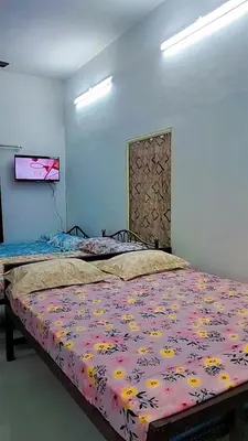 a bedroom with a bed with a floral bedspread at Mamalakandam Green Hill Stay in Diya Homesay in Mamalakandam