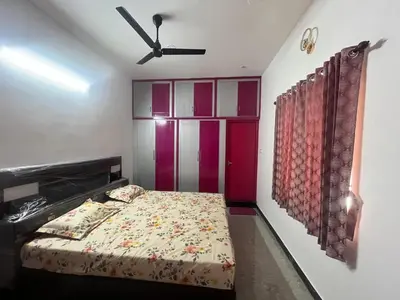 a bedroom with a bed and a ceiling fan at AC 3BHK premium house in Pollāchi