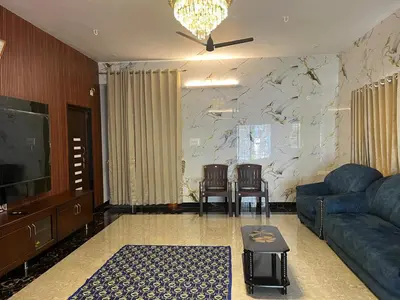 a living room with a couch and a tv at AC 3BHK premium house in Pollāchi