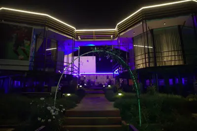 a night view of a building with purple lights at Airas Resort in Kūkkāl