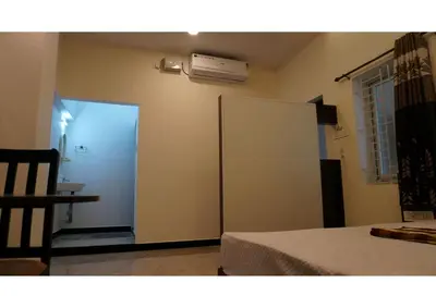 a room with a bed and a white refrigerator at Room Stay non bookable in Udumalaippettai