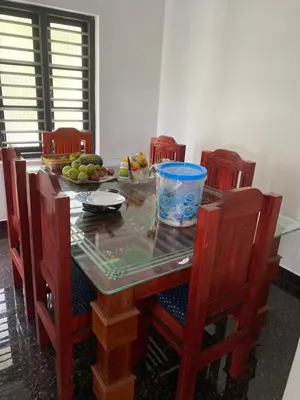 a dining room table with chairs and a bowl of fruit at Travango Settukunnu in Vythiri