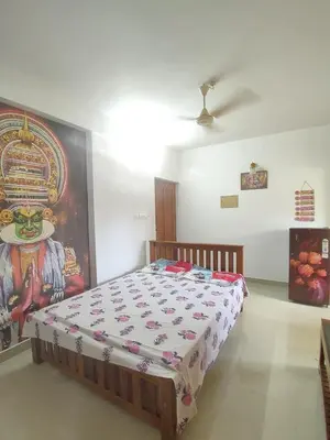 a bedroom with a bed with a painting on the wall at Guruvayur Soorya Madhavam Apartment B10, Shruthi, close to Temple, only150 Mtrs to North Nada in Guruvāyūr