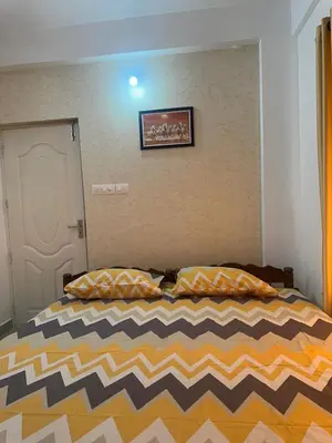 a bedroom with a bed with a striped comforter at Guruvayur Soorya Madhavam Apartment B10, Shruthi, close to Temple, only150 Mtrs to North Nada in Guruvāyūr