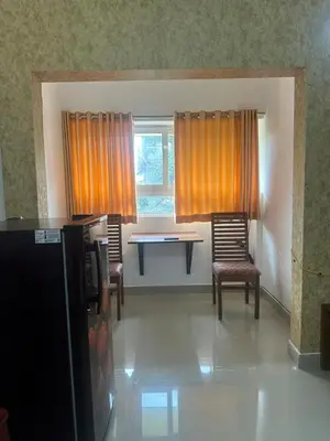 a living room with chairs and a table and a window at Guruvayur Soorya Madhavam Apartment B10, Shruthi, close to Temple, only150 Mtrs to North Nada in Guruvāyūr