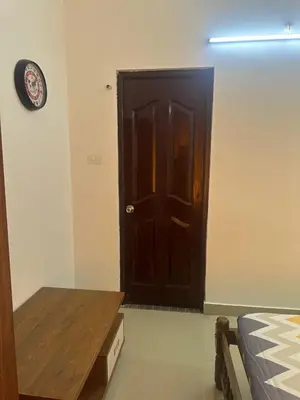 a room with a door and a table and a bed at Guruvayur Soorya Madhavam Apartment B10, Shruthi, close to Temple, only150 Mtrs to North Nada in Guruvāyūr