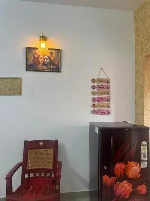 a chair and a refrigerator in a room at Guruvayur Soorya Madhavam Apartment B10, Shruthi, close to Temple, only150 Mtrs to North Nada in Guruvāyūr