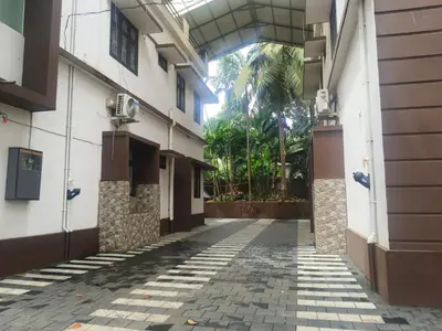an empty hallway of a building with a palm tree at Havence Villas - Kottakkal in Kottakkal