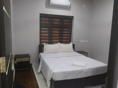 a bedroom with a bed with white sheets and a window at Havence Villas - Kottakkal in Kottakkal