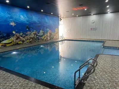 a swimming pool with an aquarium in a building at Havence Villas - Kottakkal in Kottakkal